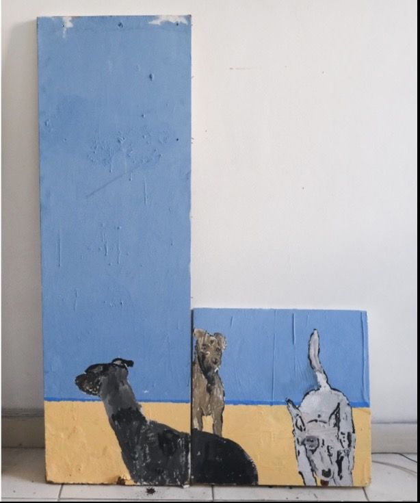 Dois painéis azuis e amarelos, de alturas diferentes, com três cachorros pintados, encostados numa parede branca.